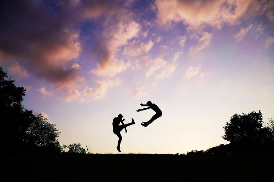 Two people fighting at sundown