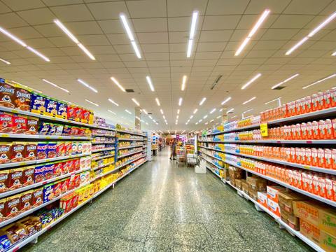 A supermarket aisle with shelves full of cereal and other boxes.