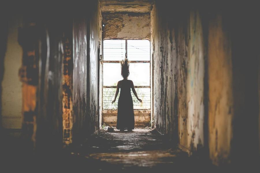 Silhouette of woman in front of a window with her hair floating.