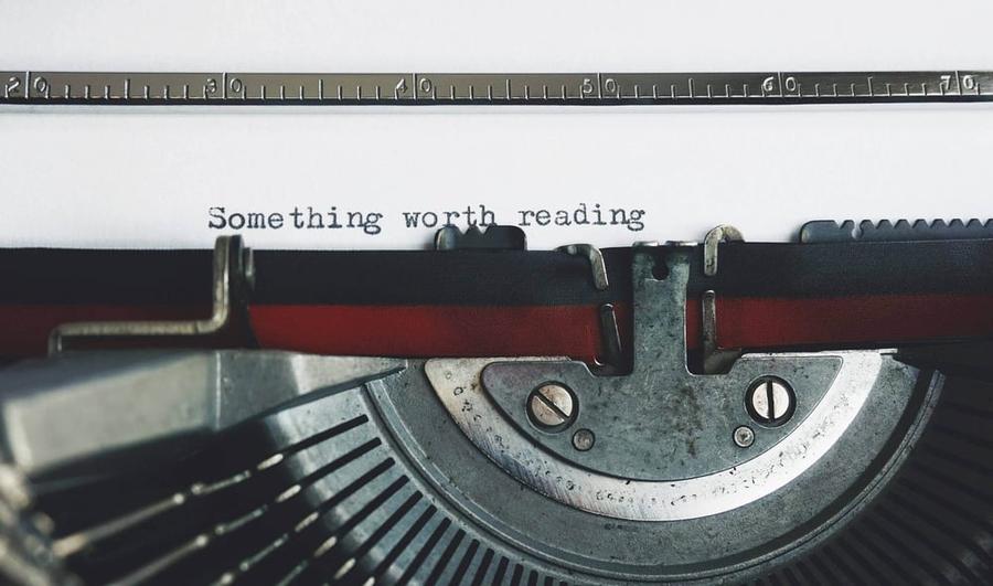 Paper in a typewriter reading "Something worth reading"