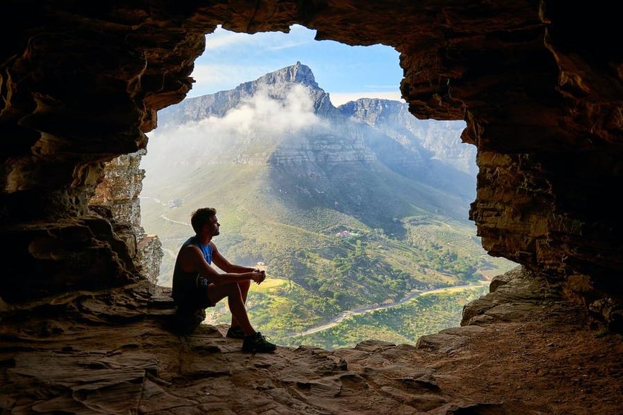 A man sitting in the mouth of a cave
