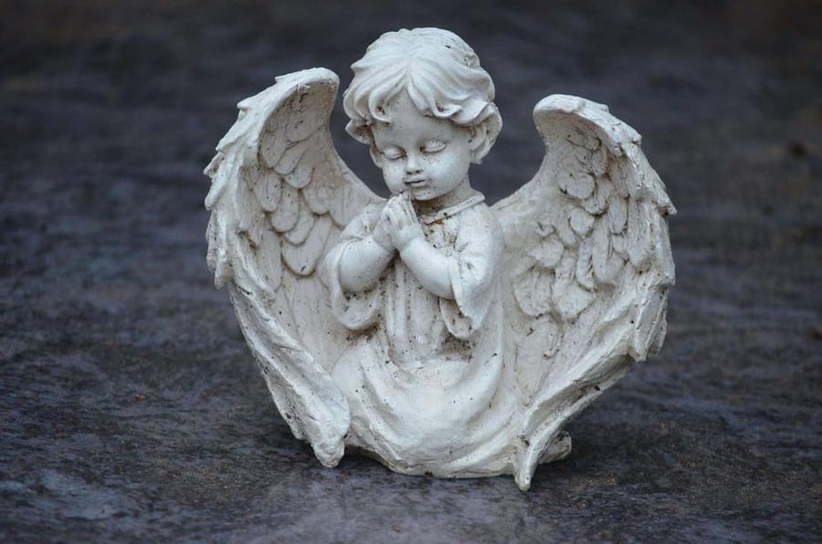 Statue of a child angel praying