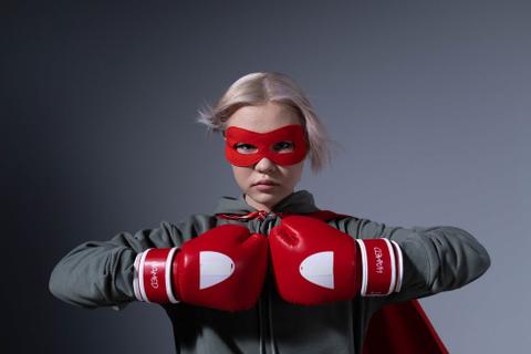 A young person in a superhero mask and boxing gloves.
