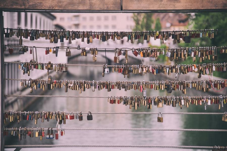 Dozens of padlocks attached to a bridge.