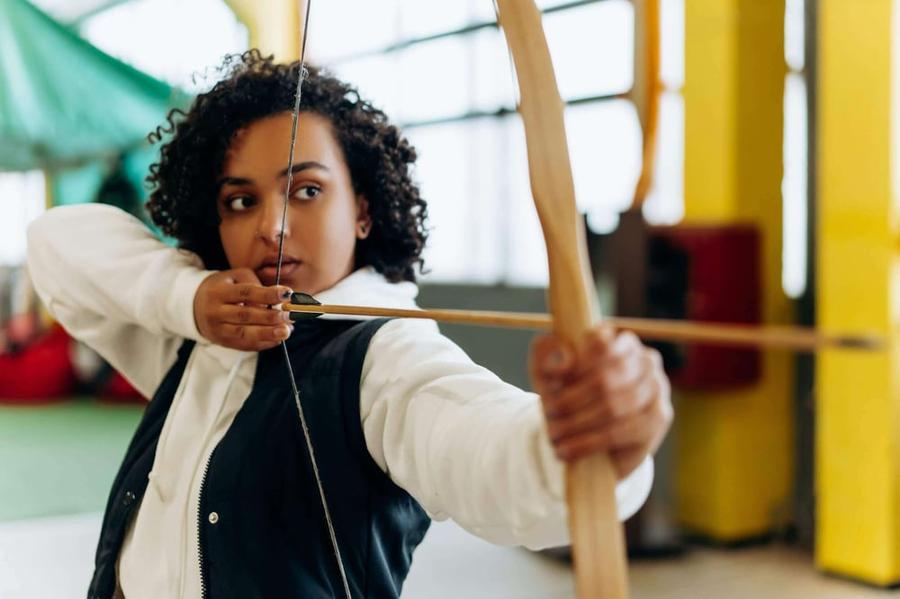 A person prepares to shoot a bow and arrow.