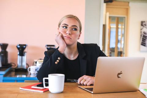 A writer thinks while sitting at a laptop computer.