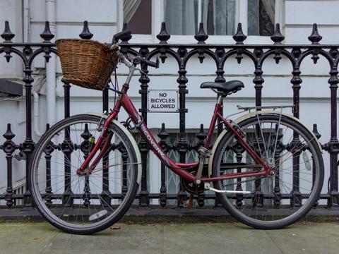 A bicycle sitting in front of a "no bicycles" sign.