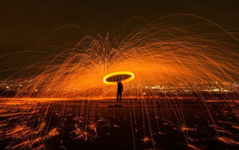 A man with a circle of sparks above him