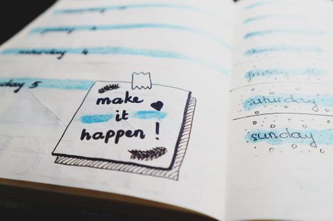 Notebook with a note saying "Make it happen!"