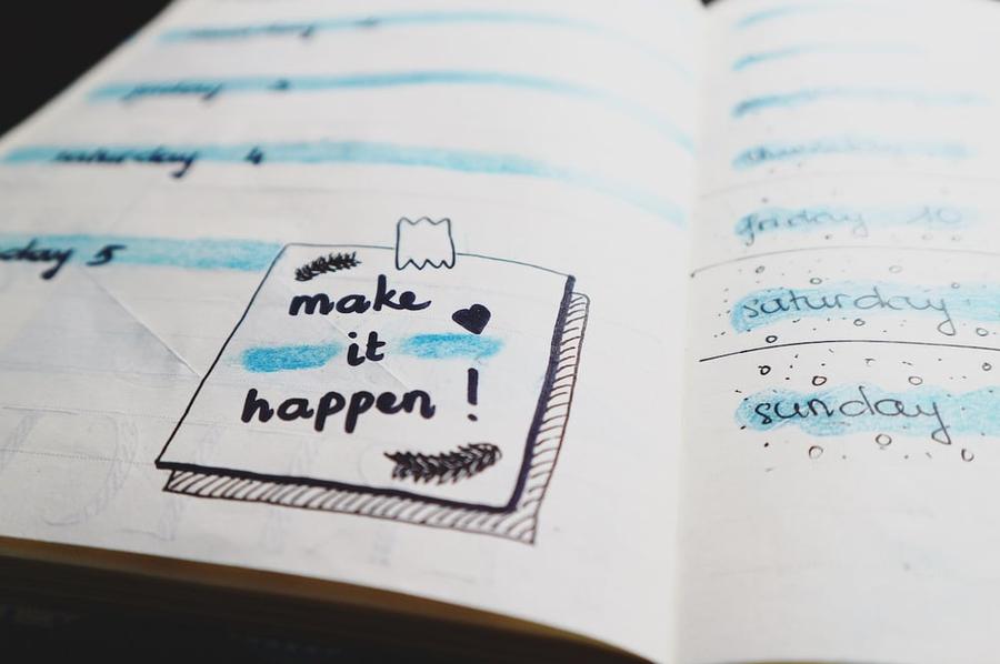 Notebook with a note saying "Make it happen!"