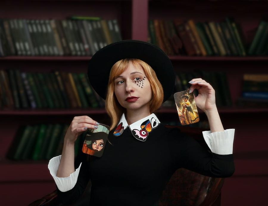 Woman holding cards in front of a bookshelf