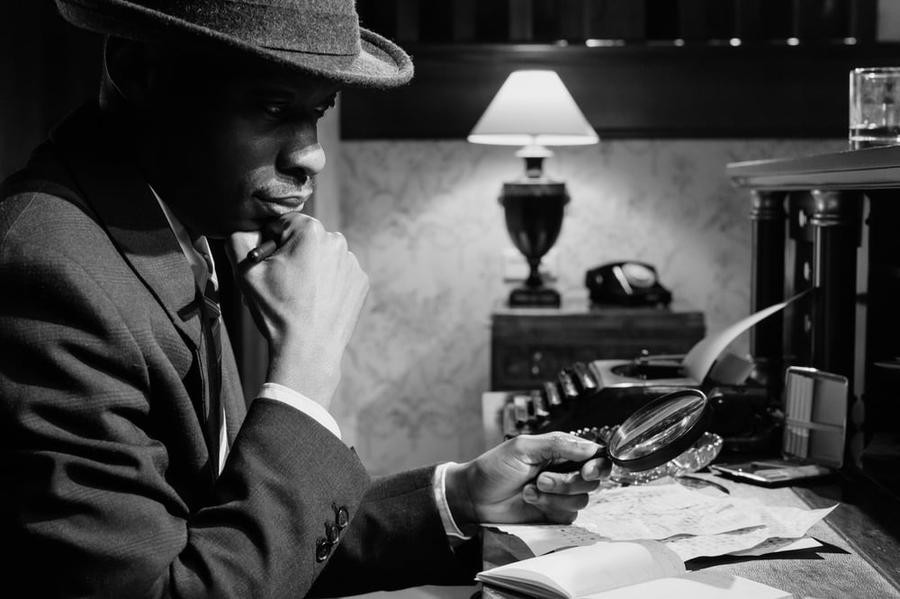 A detective sits at a desk.