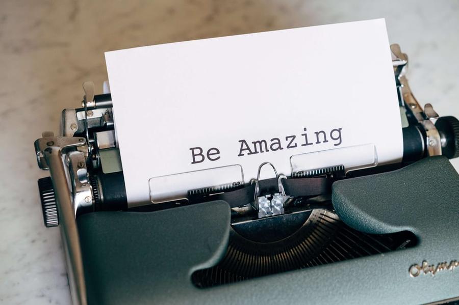 Close up of a page on a typewriter with the words "Be Amazing" typed on the page.