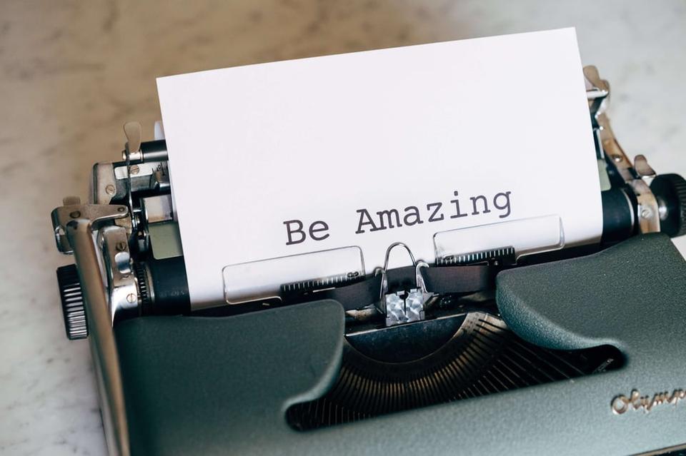 Close up of a page on a typewriter with the words "Be Amazing" typed on the page.