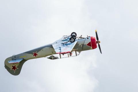 Red and white airplane flying upside down.