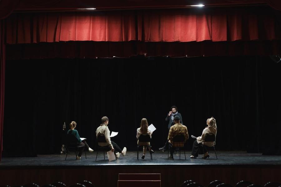 A group of people sitting on chairs on a stage.