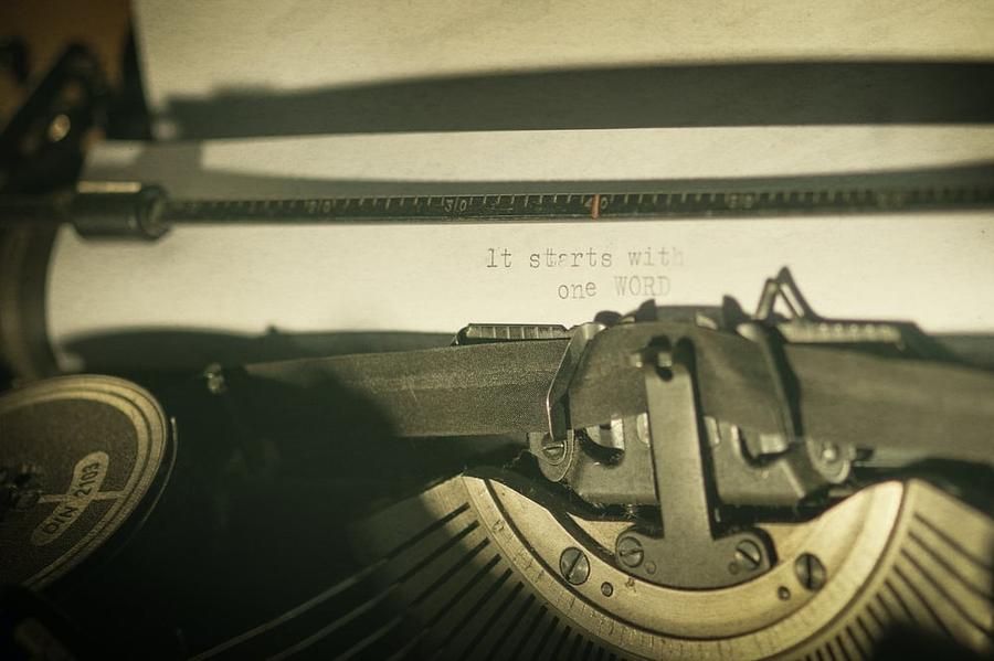 An opening line typed on a sheet of paper in an old typewriter.