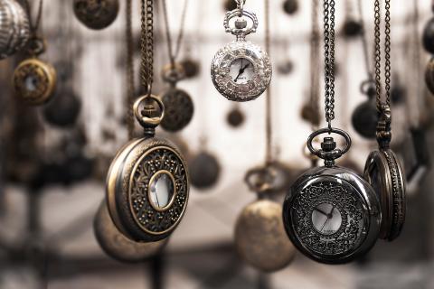 Several pocket watches hanging from chains.