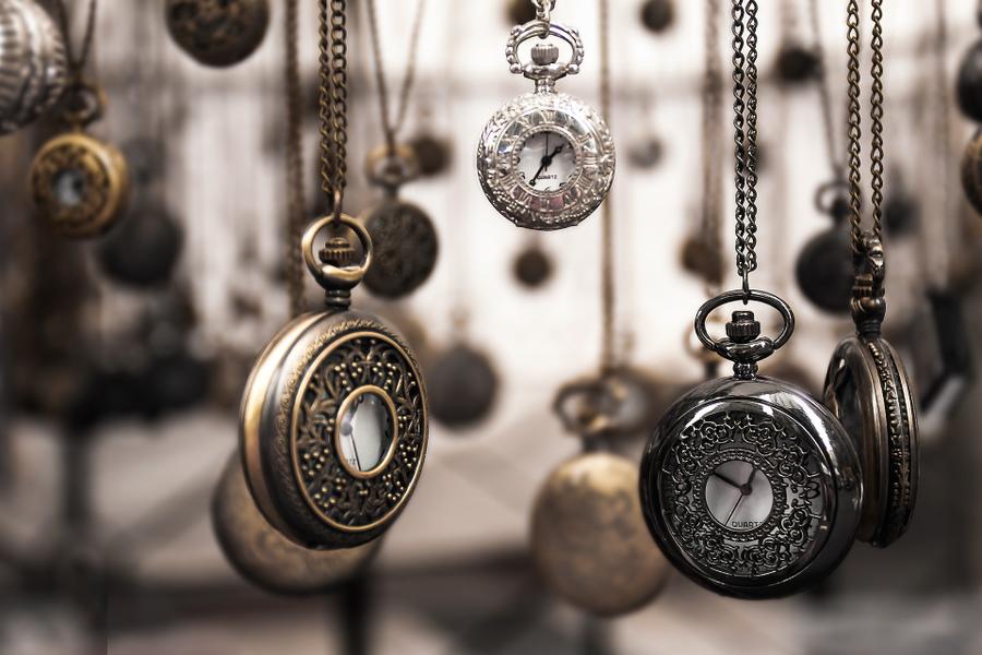 Several pocket watches hanging from chains.