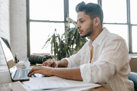A person types on a computer in a clean, white space.