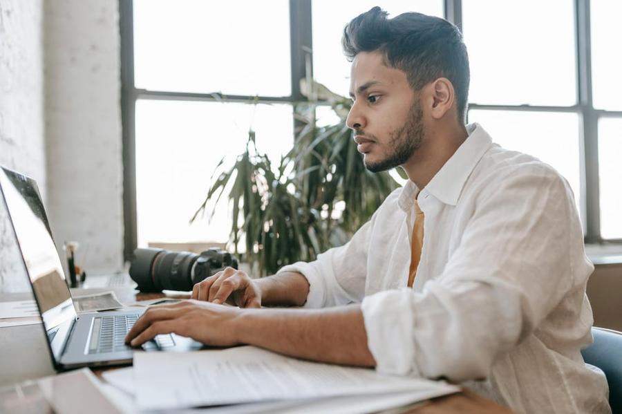 A person types on a computer in a clean, white space.