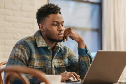 A writer stares thoughtfully at a computer.