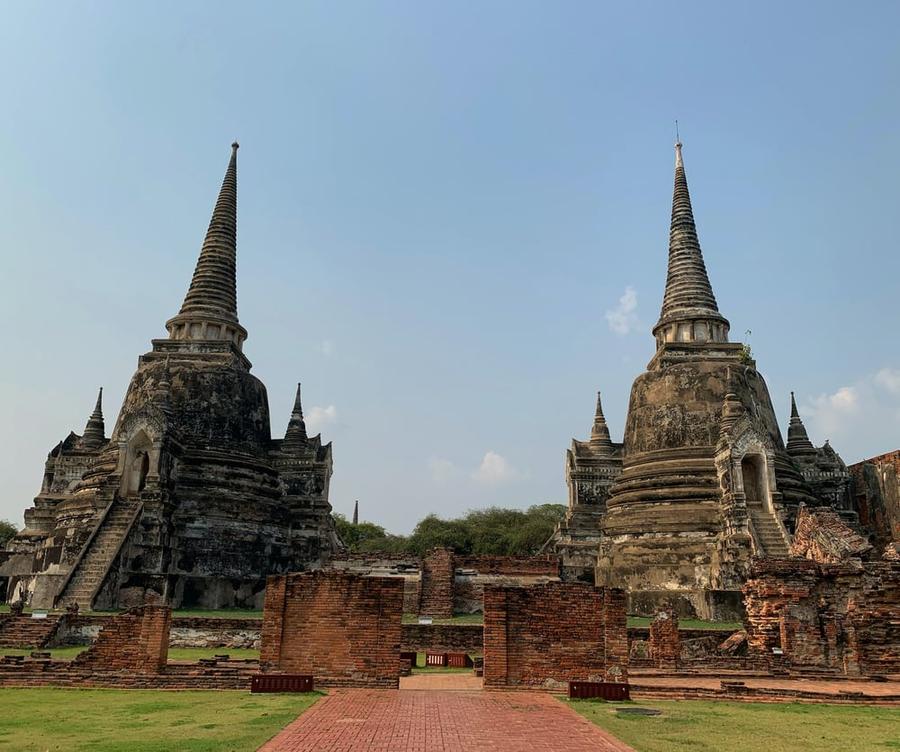 Wat Phra Si Sanphet Temple in Thailand—an ornate stone temple on lush green land.