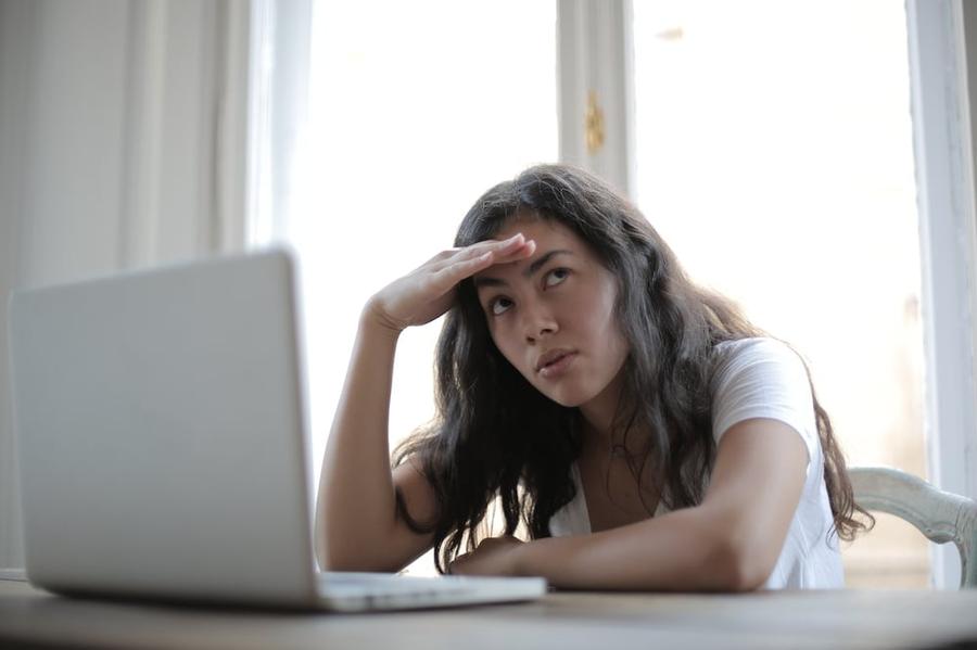 Confused woman staring at her laptop.
