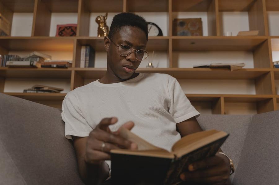 A person reads a book with a thoughtful expression on their face.