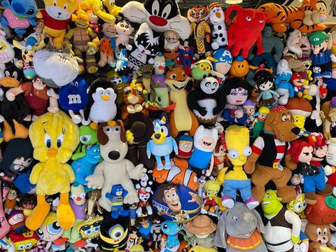 A pile of different character toys, including Tweety Bird, Bart Simpson, Wonder Woman, and more.