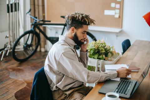 A writer sits at a desk in an office.