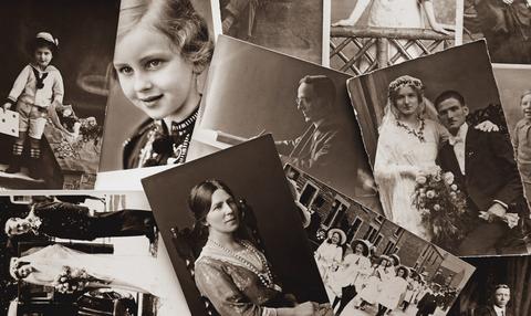 Several black and white photographs of historical figures scattered on a surface.