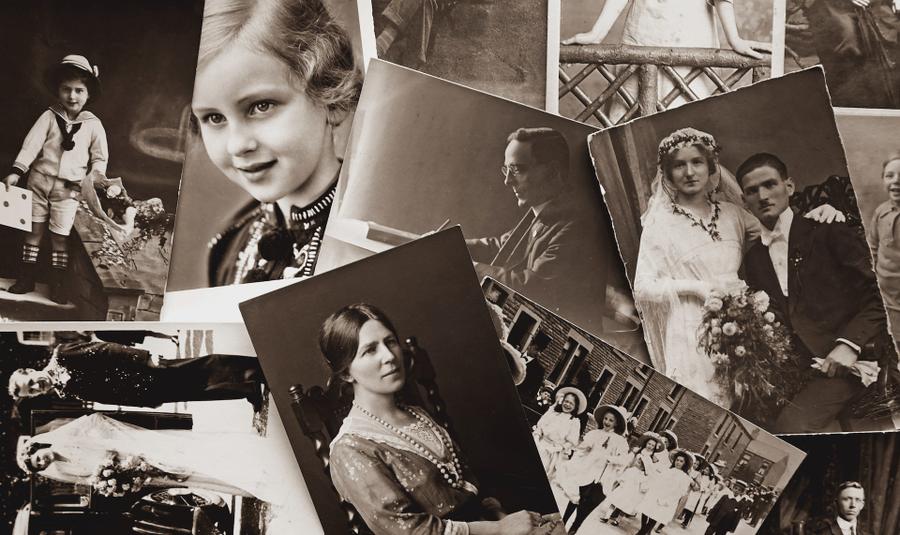 Several black and white photographs of historical figures scattered on a surface.