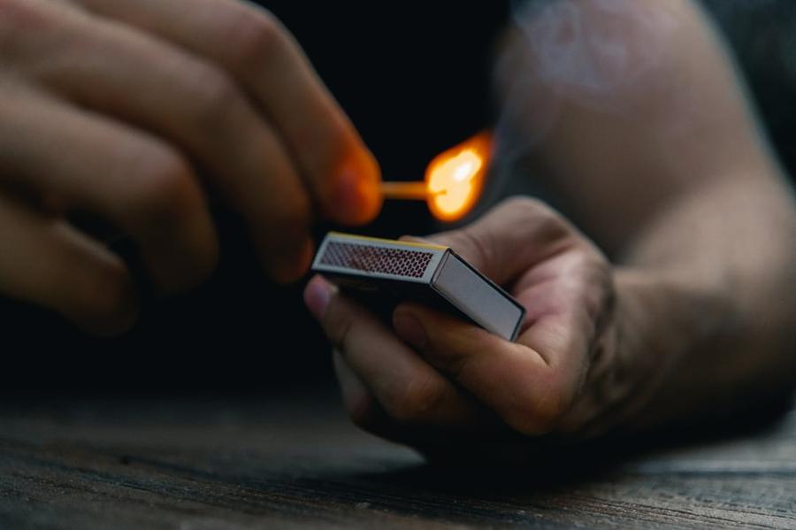 A hand strikes a match.