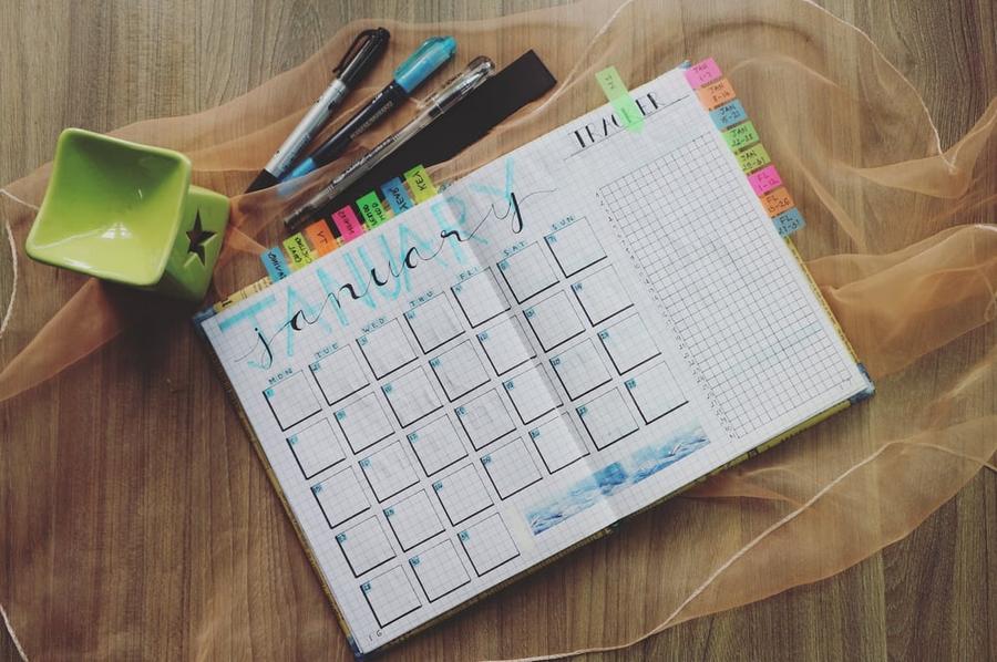 An planner with several sticky tabs on it open to the month of January.