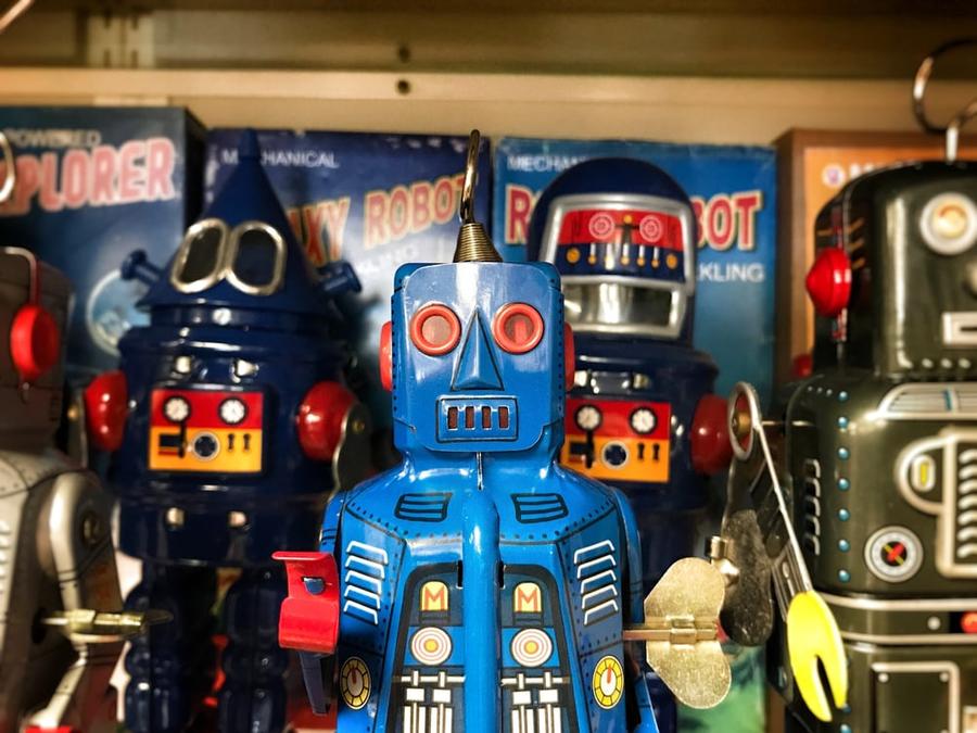 Retro toy robots in front of their boxes.