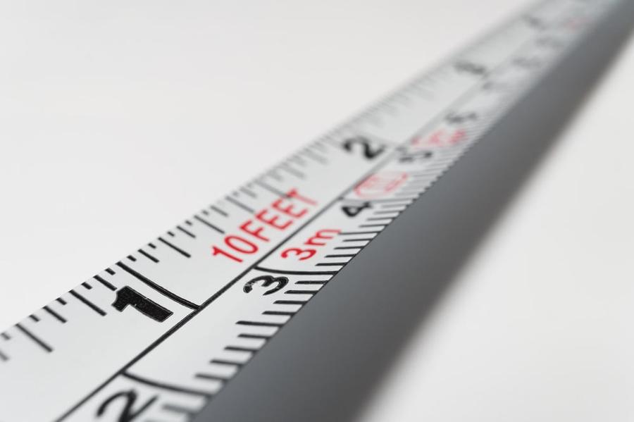 A measuring tape stretched out over a white background.