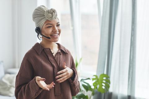 A literary agent smiles while talking on a headset.