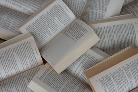 A messy pile of open books.