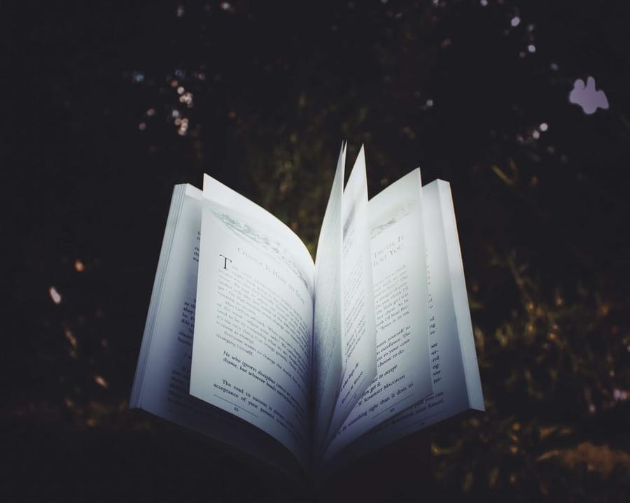 An open book with a dark background.