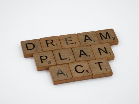 Wooden letter tiles spelling "Dream, plan, act"