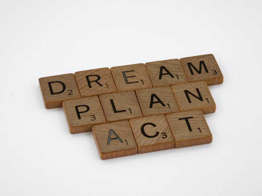 Wooden letter tiles spelling "Dream, plan, act"