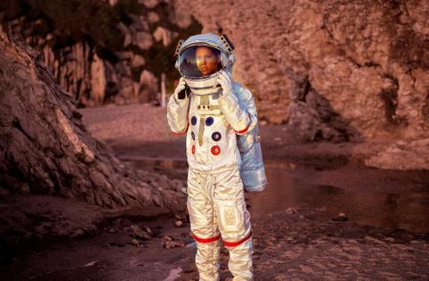 An astronaut stands alone on Mars.