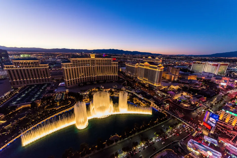 The Bellagio fountains at dusk, with the Strip beyond.