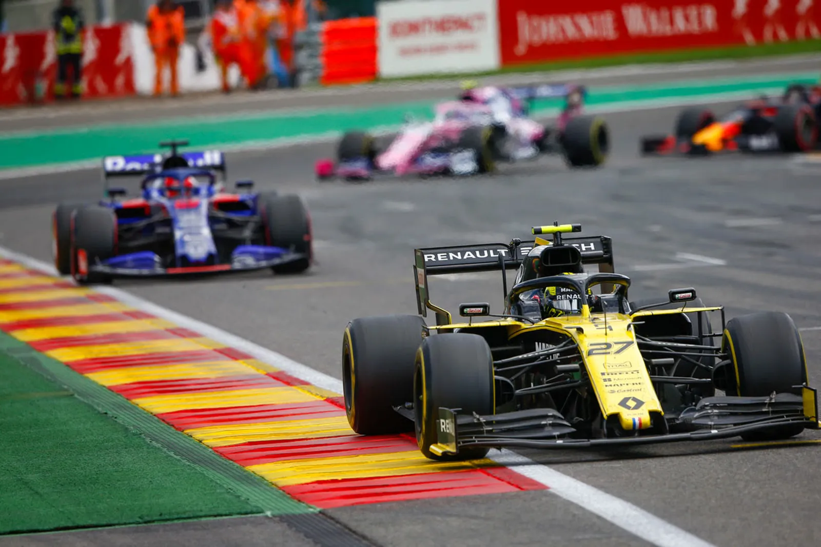 Formula 1 cars riding the kerbs in close company.