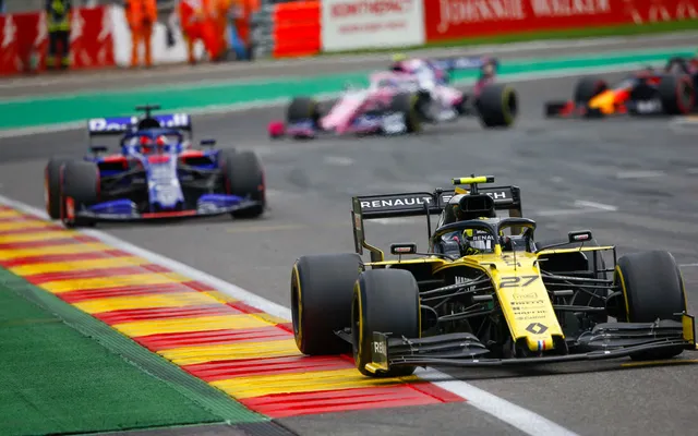 Formula 1 cars riding the kerbs in close company.