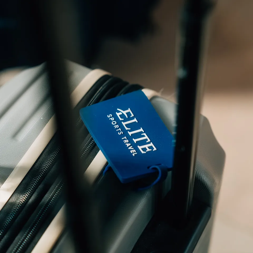 An Elite Sports Travel luggage tag on a suitcase.