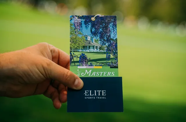 A Masters patron badge held up against the course.