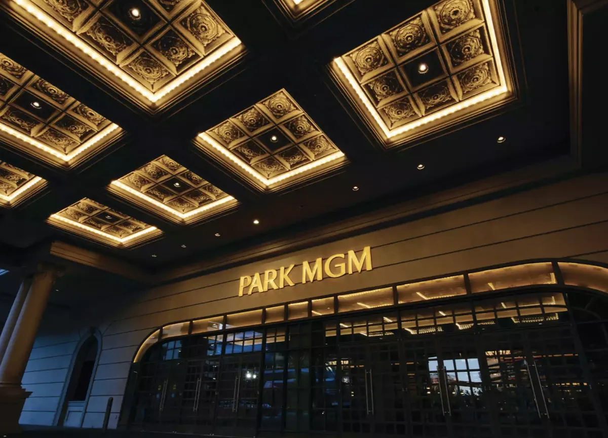 The Park MGM entrance at night, its name lit in gold beneath a coffered ceiling.