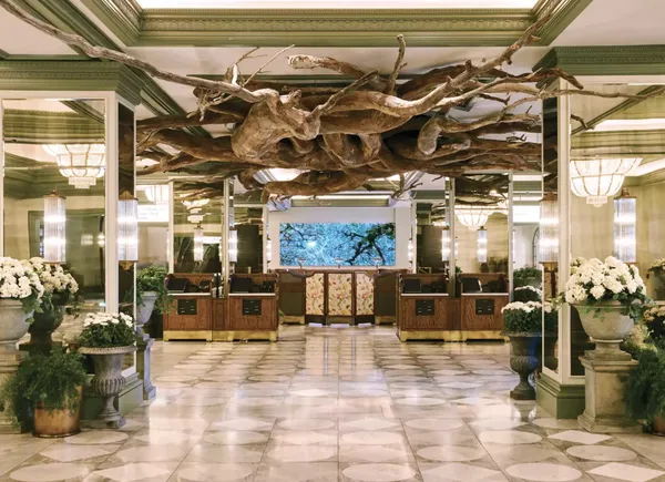 The Park MGM lobby: a marble floor, check-in desks, and a sculpted driftwood canopy overhead.